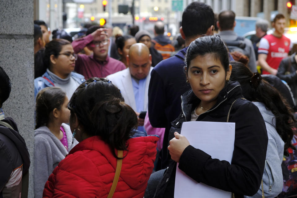 Hundreds of people overflow onto the sidewalk in a line snaking around the block outside a U.S. immigration office with numerous courtrooms Thursday, Jan. 31, 2019, in San Francisco. U.S. immigration officials blame the government shutdown and the extreme winter weather for confusion about immigration court hearings. In an emailed statement, the part of the Justice Department overseeing immigration courts said some immigrants with notices to appear Thursday wouldn't be able to proceed with those hearings. The Executive Office for Immigration Review said the shutdown prevented immigration courts from issuing new hearing notices. (AP Photo/Eric Risberg)