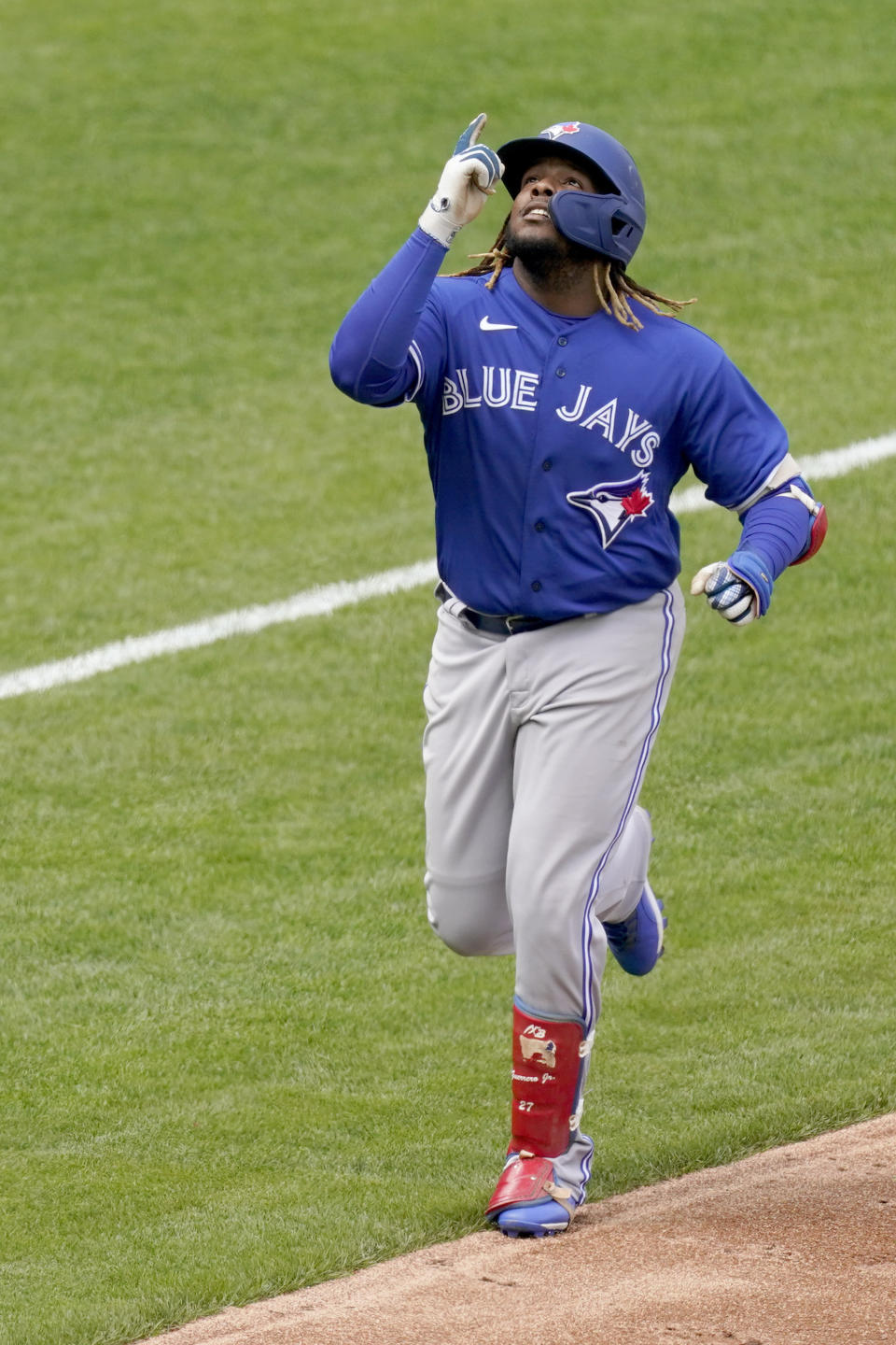 El dominicano Vladimir Guerrero, de los Azulejos de Toronto, festeja antes de anotar con el jonrón que él mismo conectó en el juego del sábado 17 de abril de 2021, frente a los Reales de Kansas City (AP Photo/Charlie Riedel)