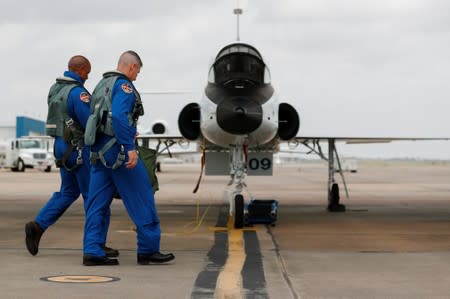 NASA commercial crew astronauts Victor Glover and Michael Hopkins walk out to their aircraft prior to a training flight in Houston, Texas