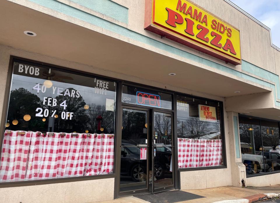 Signs in the windows of Mama Sid's Pizza on Jan. 31, 2023 in Athens, Ga. celebrate its 40-year legacy as the city's longest-running pizzeria restaurant.