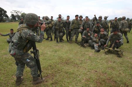 A member of the Philippine Marine Battalion Landing Team (MBLT) takes pictures of his comrades during their send-off ceremony. REUTERS/Romeo Ranoco