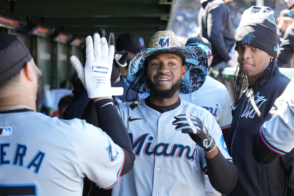 Miami Marlins' Bryan De La Cruz celebrates his home run in the dugout off Chicago Cubs starting pitcher Jameson Taillon during the fourth inning of a baseball game Friday, April 19, 2024, in Chicago. (AP Photo/Charles Rex Arbogast)