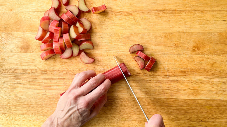 Slicing rhubarb stalks on cutting board