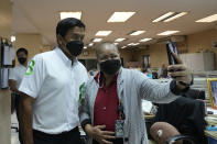 A supporter takes a selfie with Bangkok governor independent candidate Chadchart Sittipunt, left, during an election campaign in Bangkok, Thailand Tuesday, May 17, 2022. Residents of the Thai capital Bangkok will cast their ballots for the city’s leader Sunday in a vote seen as a barometer of the public mood ahead of an approaching general election. (AP Photo/Sakchai Lalit)