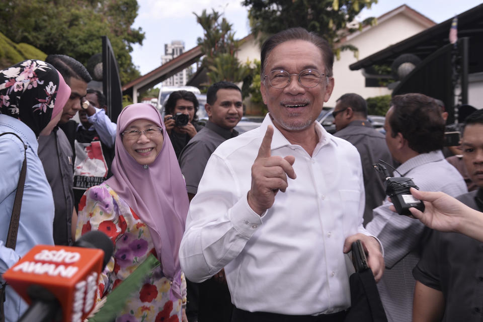 Politician Anwar Ibrahim, right, gestures next to his wife Wan Azizah Ismail as they head to their party headquarters after meeting the king in Kuala Lumpur, Malaysia, Wednesday, Feb. 26, 2020. Malaysia's king held unusual consultations with lawmakers for a second day Wednesday to resolve a political vacuum caused by the abrupt collapse of the ruling coalition and the resignation of Prime Minister Mahathir Mohamad. (AP Photo)