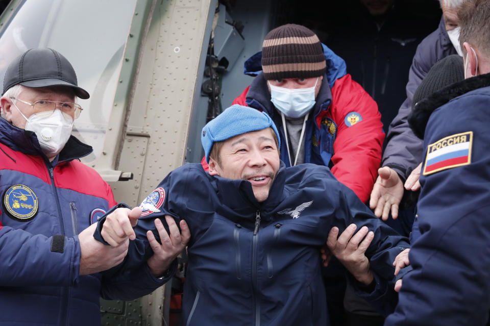 Space flight participant Japanese entrepreneur Yusaku Maezawa disembarks from a helicopter as he arrives at the airport after returning from the International Space Station on the Soyuz MS-20 space capsule, in Zhezkazgan, Kazakhstan, Monday, Dec. 20, 2021. A Japanese billionaire, his producer and a Russian cosmonaut safely returned to Earth on Monday after spending 12 days on the International Space Station. (Shamil Zhumatov/Pool Photo via AP)