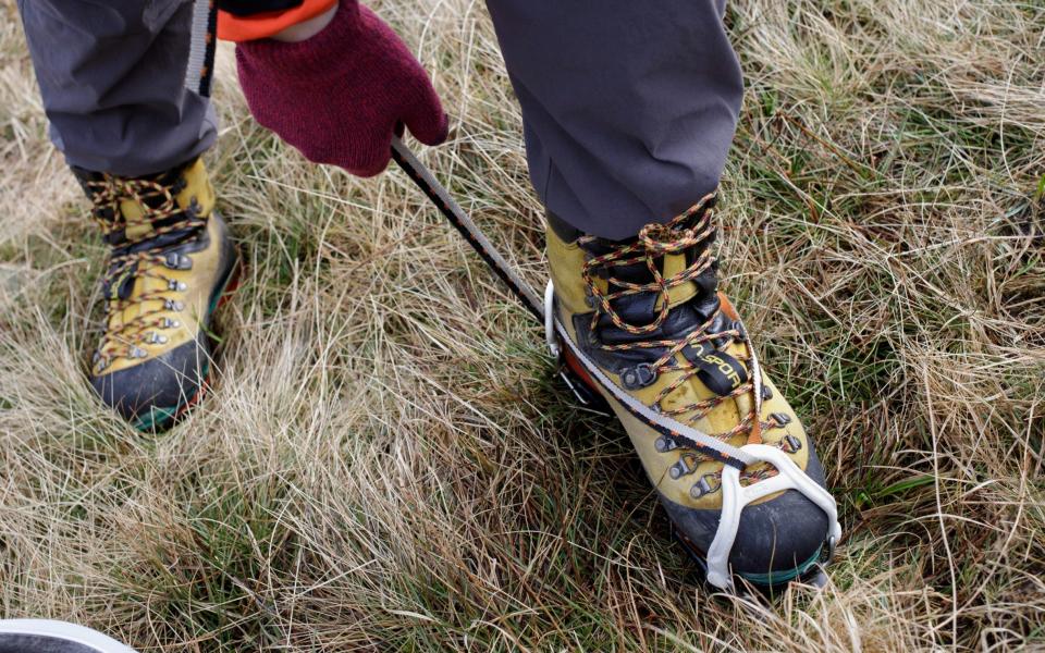 Winter Walking Skills Day Course in the Lake District.  Telegraph writer Jack Rear puts on his crampons at the foot of Helvellyn.