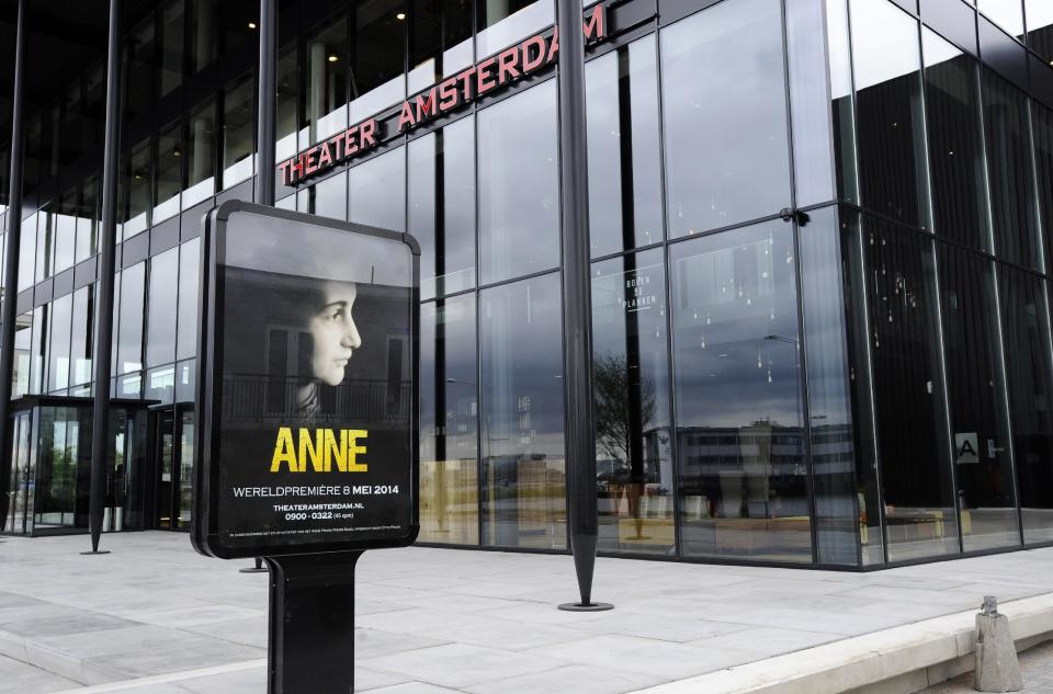 This photo taken Friday, May 2, 2014 shows a poster of the new Anne Frank play in front of Theater Amsterdam. Seeking to engage a new generation with the tragic story of Anne Frank, a major new play based on the Jewish teenager's diary opens Thursday, May 8, 2014 in Amsterdam. It's the first time a theatrical production has been forged directly from Frank's actual writings since the award-winning 1950s play that escalated her story, then little-known, to the world's attention. It's being staged in a purpose-built 1,100 seat theater that includes a replica of the secret apartment where Frank and her family hid from the Nazis in World War II. (AP Photo/Evert Elzinga)