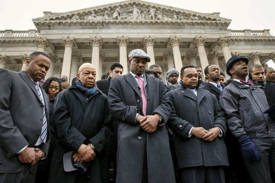 FILE - In this Thursday, Dec. 11, 2014 file photo, congressional staff members gather at the Capitol to raise awareness of the recent killings of black men by police officers, both of which did not result in grand jury indictments, in Washington. They are joined by Rep. Elijah Cummings, D-Md., second from left, and Senate Chaplain Barry Black, far right. The walkout came as both houses of Congress attempt to pass a spending measure and avert government shutdown. (AP Photo/J. Scott Applewhite)