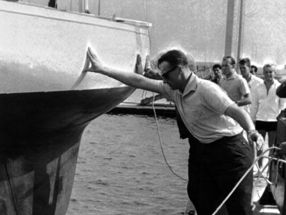 King Harald of Norway, then a prince, leans on a boat at the Olympics