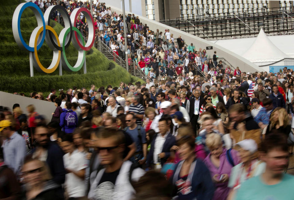 In Sunday, July 29, 2012 photo, visitors leave the Aquatic Center at the Olympic Park during the 2012 Summer Olympics, in London. (AP Photo/Emilio Morenatti)