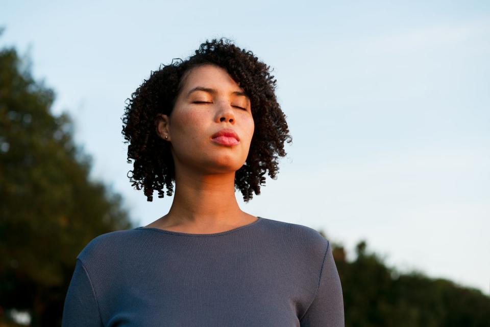 woman with her eyes closed breathing calmly