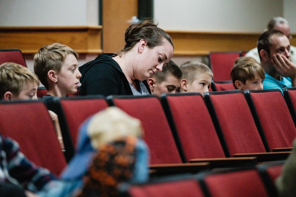 Regina MIller, of Mineral City, takes notes while sitting with her five sons and husband, Dave, at far right, during a special program on ticks, at New Philadelphia High School. Members of the MIller family have contracted Lyme disease four times.