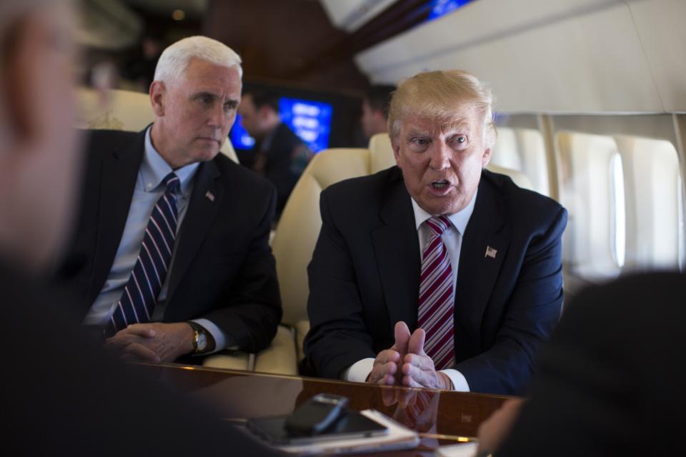 Donald Trump talks with the press, on Sept. 5, 2016, as he flies on board his campaign plane, as Vice presidential candidate Gov. Mike Pence, R-Ind., left, looks on. (Photo: Evan Vucci/AP)