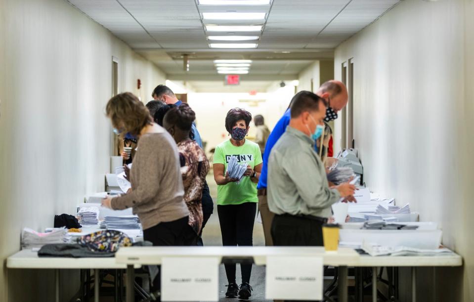 Jeri Shuits, center, office manager for the Beaver County Board of Elections, walks between election workers preparing ballots for counting in the basement of the Beaver County Courthouse on Wednesday, Nov. 4, 2020, in Beaver, Pa.