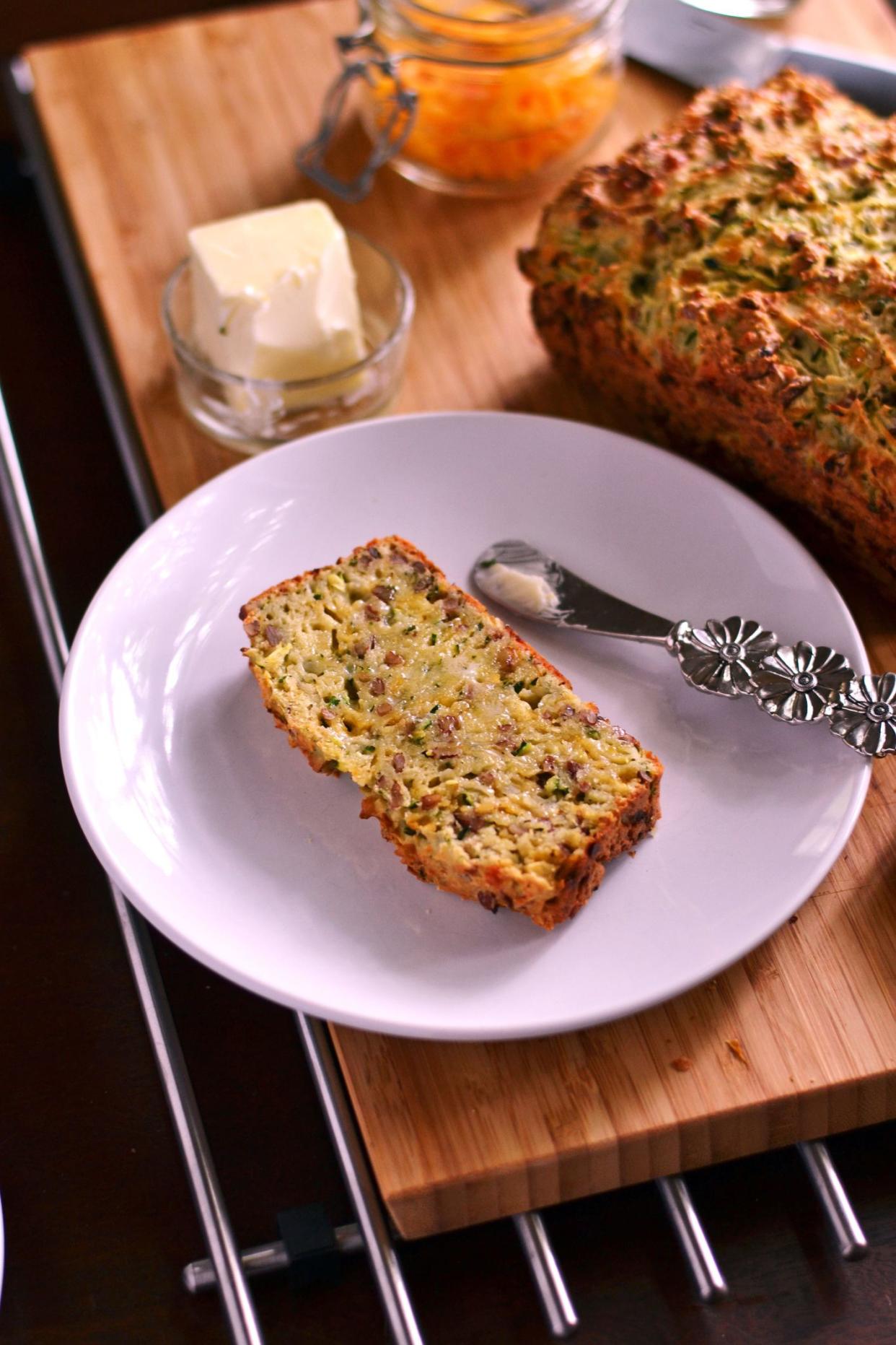 Freshly baked Zucchini Bread topped with shredded cheddar and softened butter.