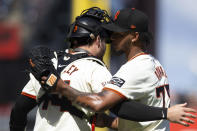 San Francisco Giants catcher Patrick Bailey (14) and San Francisco Giants pitcher Camilo Doval (75) celebrate their victory over the San Diego Padres in a baseball game, Sunday, April 7, 2024, in San Francisco. (AP Photo/D. Ross Cameron)