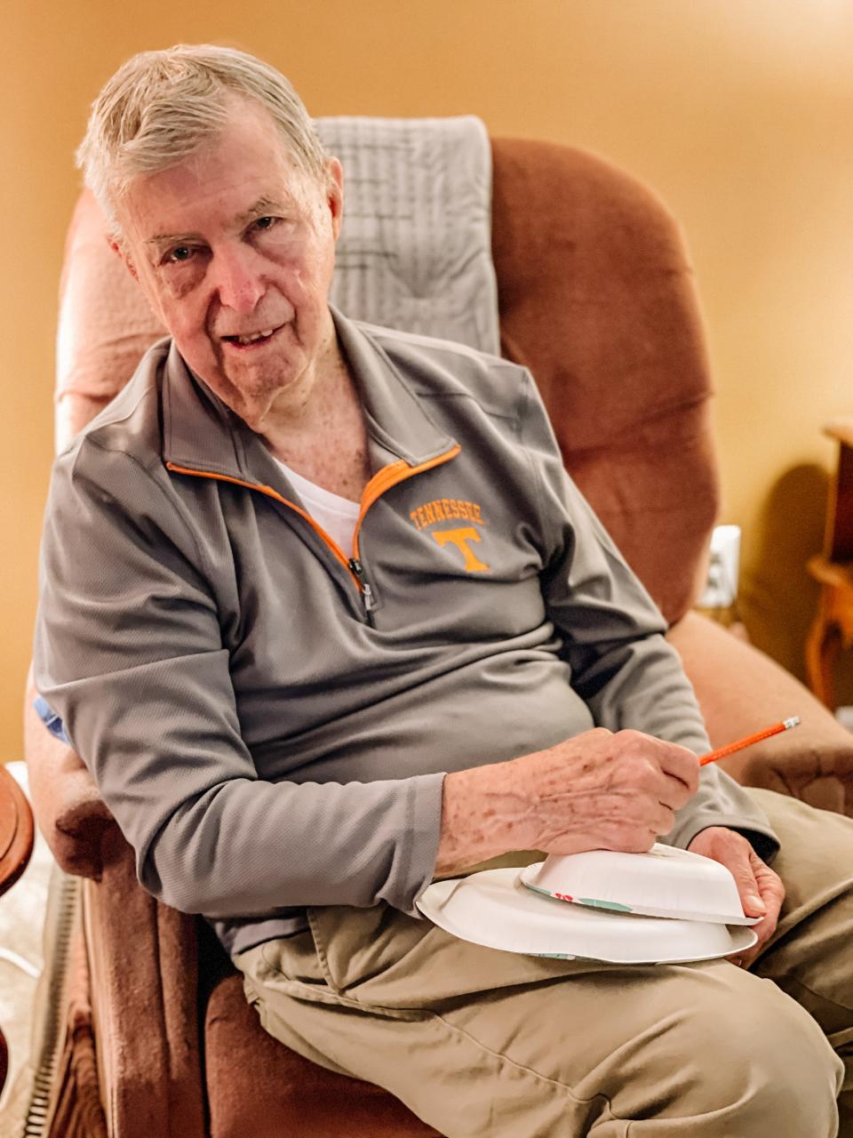 92-year-old Gene Money, who suffers from Parkinson’s disease, always has a ready supply of paper plates stored in his walker to draw portraits. Halls, Jan. 31, 2022.