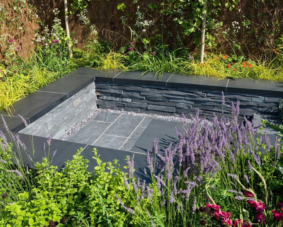 5. Double up bordering raised beds as chic slate-topped seating