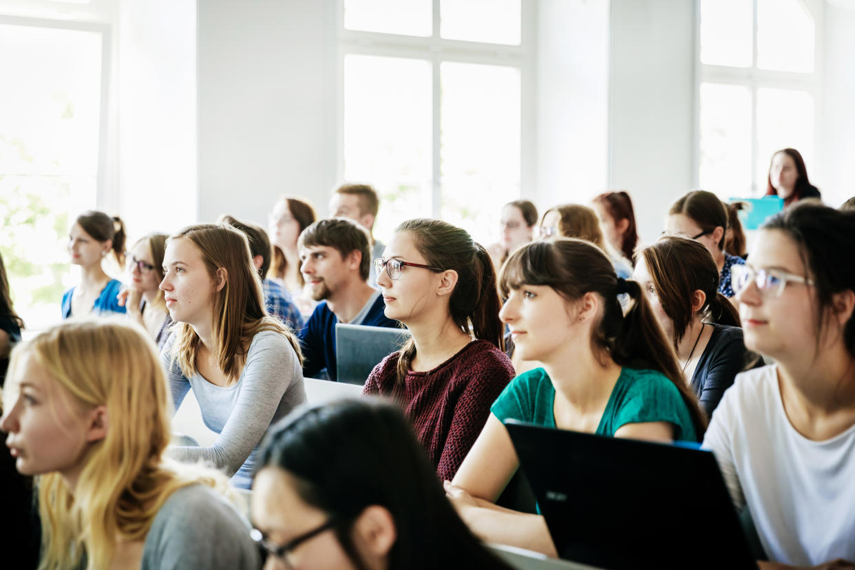 students with laptops, A group of students listening and concentrating on their tutor during a lecture at university.