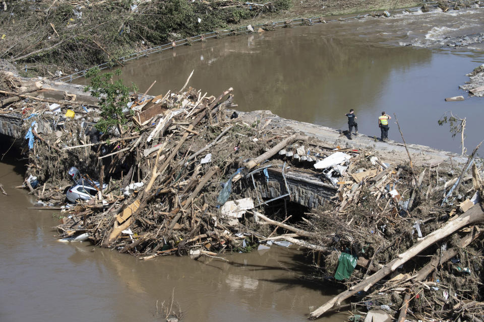 Police officers search in the rubble for possible victims, at a bridge over the River Ahr, in Altenahr, western Germany, Sunday, July 18, 2021. Heavy rains caused mudslides and flooding in the western part of Germany. Multiple have died and are missing as severe flooding in Germany and Belgium turned streams and streets into raging, debris-filled torrents that swept away cars and toppled houses. (Boris Roessler/dpa via AP)
