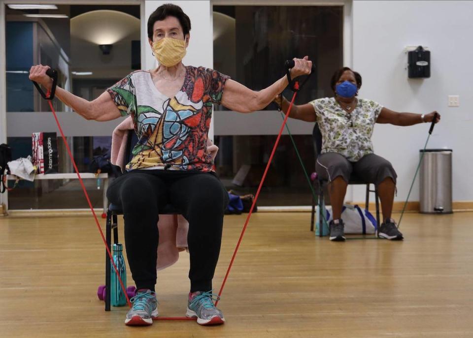 Carole Horowitz, left, and Verma Anderson, right, work out with bands during the SilverSneakers classes at the Alper Jewish Community Center in Kendall. Several Medicare Advantage and Medigap plans offer SilverSneakers fitness classes.