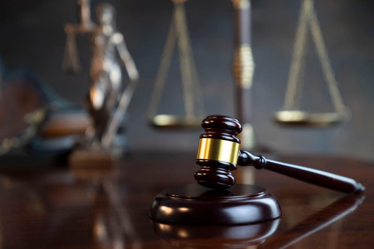 Gavel of  the judge, Themis statue, the clock and the scale on the gray background.