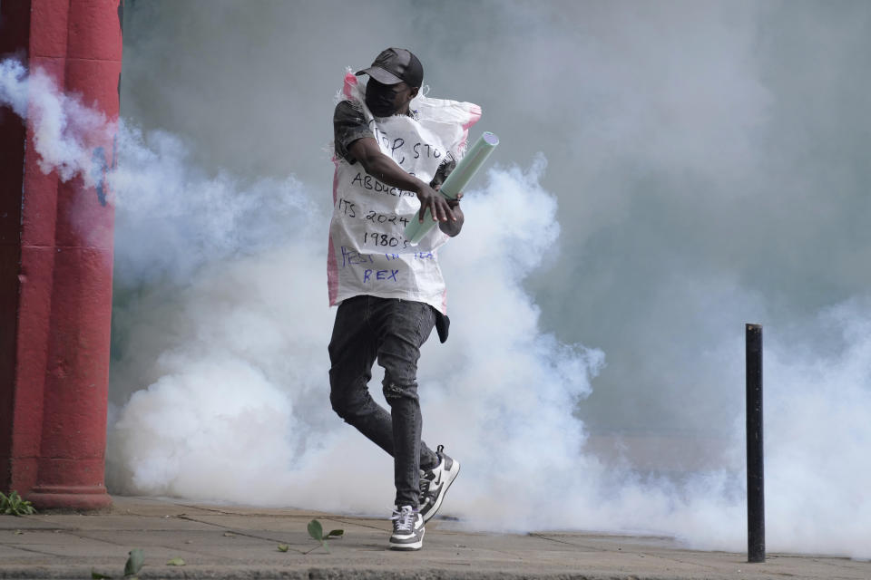A protester returns back a teargas canister to Kenya police in Nairobi, Kenya Thursday, June 27, 2024. Kenyan police on Thursday clashed with protesters in Nairobi before planned protests against a contentious finance bill, despite the president's decision not to sign it after the plans sparked deadly chaos in the capital and saw protesters storming and burning part of the parliament building. (AP Photo/Brian Inganga)