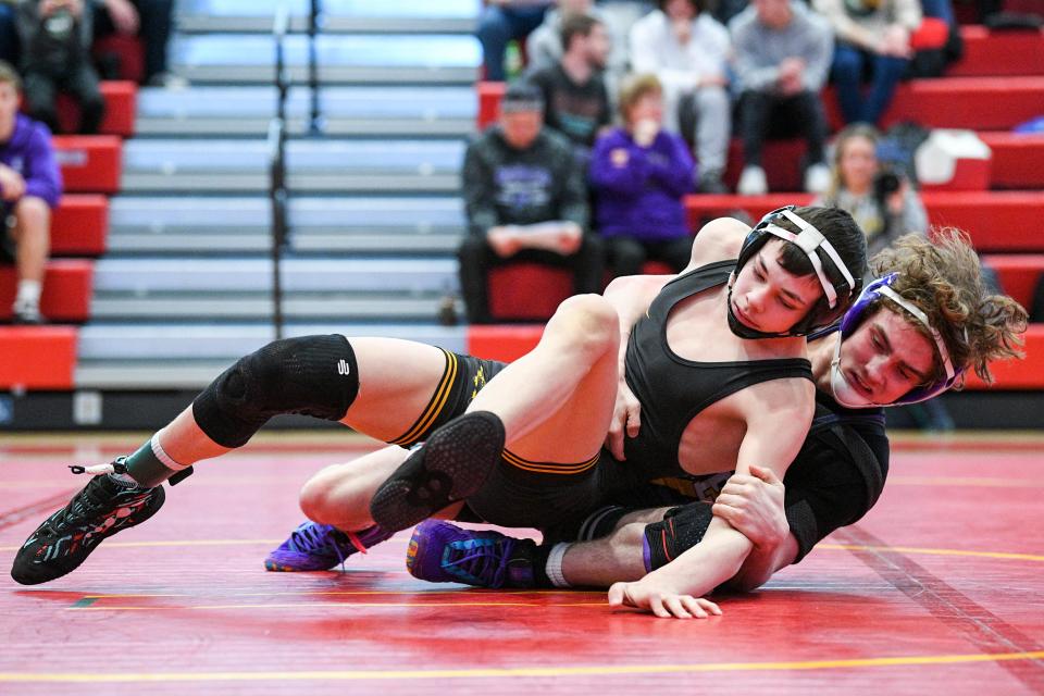 Southeast Polk's Logan Trenary, front, wrestles Waukee's Cory Jones at 120 pounds during a Class 3A district tournament at Carlisle High School on Saturday.