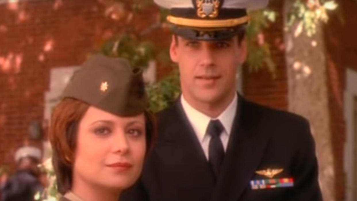  Catherine Bell and David James Elliot stand together outside in JAG. 