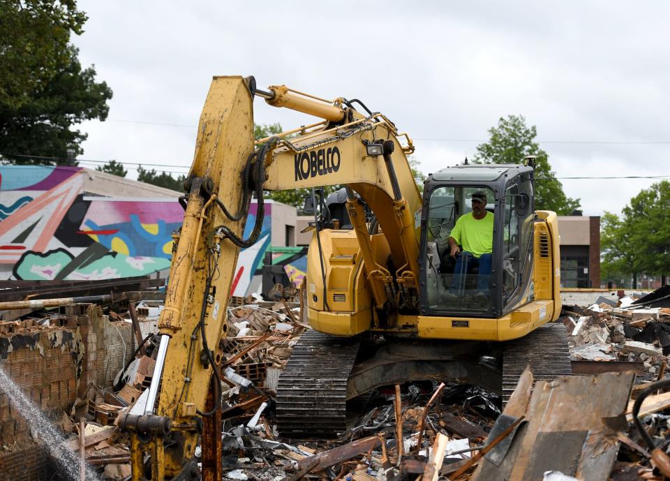 Workers with The Joseph A. Jeffries Co., including backhoe operator Tony Gaetano, demolish the former ArtsinStark office building at the corner of Ninth Street and Cleveland Avenue NW. The site will be part of a green space and park project scheduled for completion next summer.