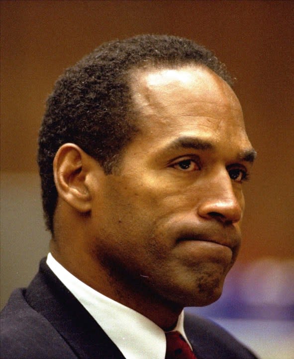 FILE – O.J. Simpson bites his lip Friday, July 8, 1994, as he listens to Dr. Irwin L. Golden, a medical examiner, describe the extent of Nicole Simpson Brown’s wounds during testimony in Los Angeles Criminal Courts. Simpson, the decorated football superstar and Hollywood actor who was acquitted of charges he killed his former wife and her friend but later found liable in a separate civil trial, has died. He was 76. (AP Photo/Eric Draper, File)