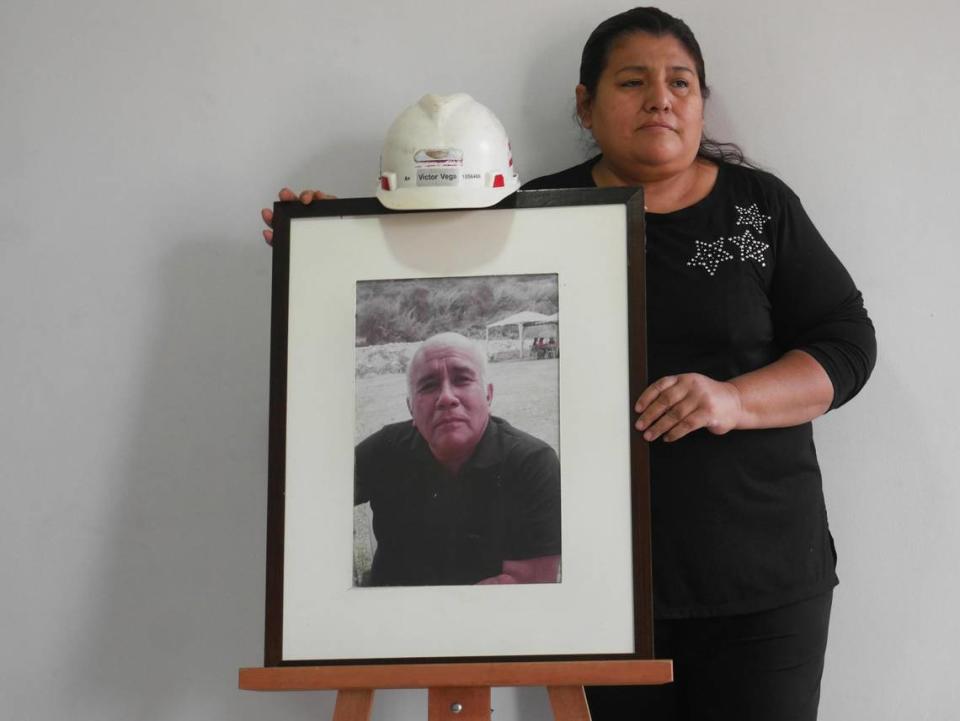 Julia Guzmán stands next to a photo of her husband, Victor, who died after contracting COVID-19, at her home in Lima, Peru, on May 11, 2021.