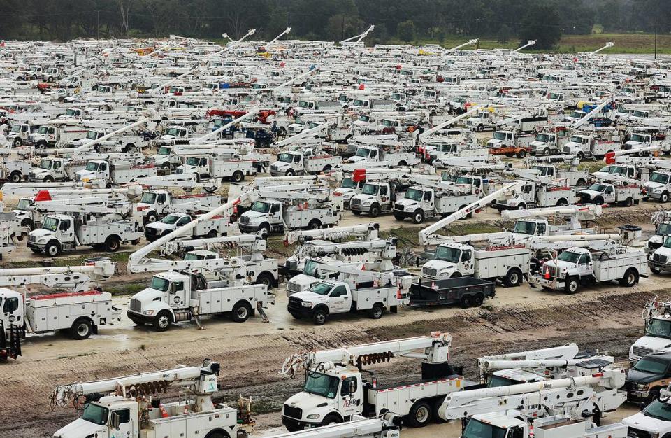 Utility trucks are staged in a rural lot in The Villages of Sumter County, Fla., on Wednesday morning, Sept. 28, 2022, in preparation for Hurricane Ian.