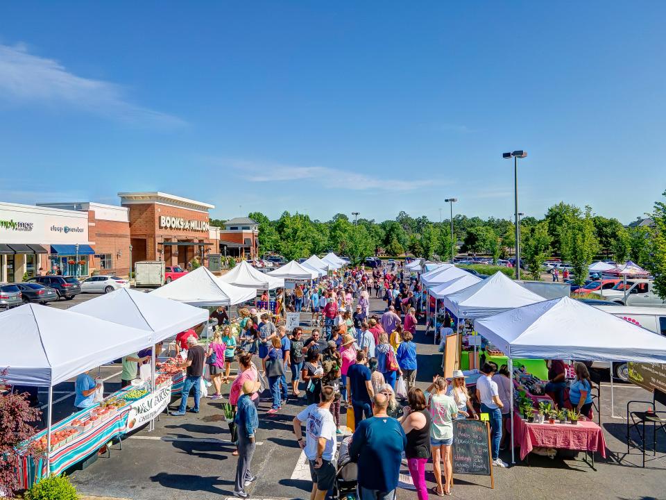 People browse booths at an annual farmers market at The Shoppes at EastChase.