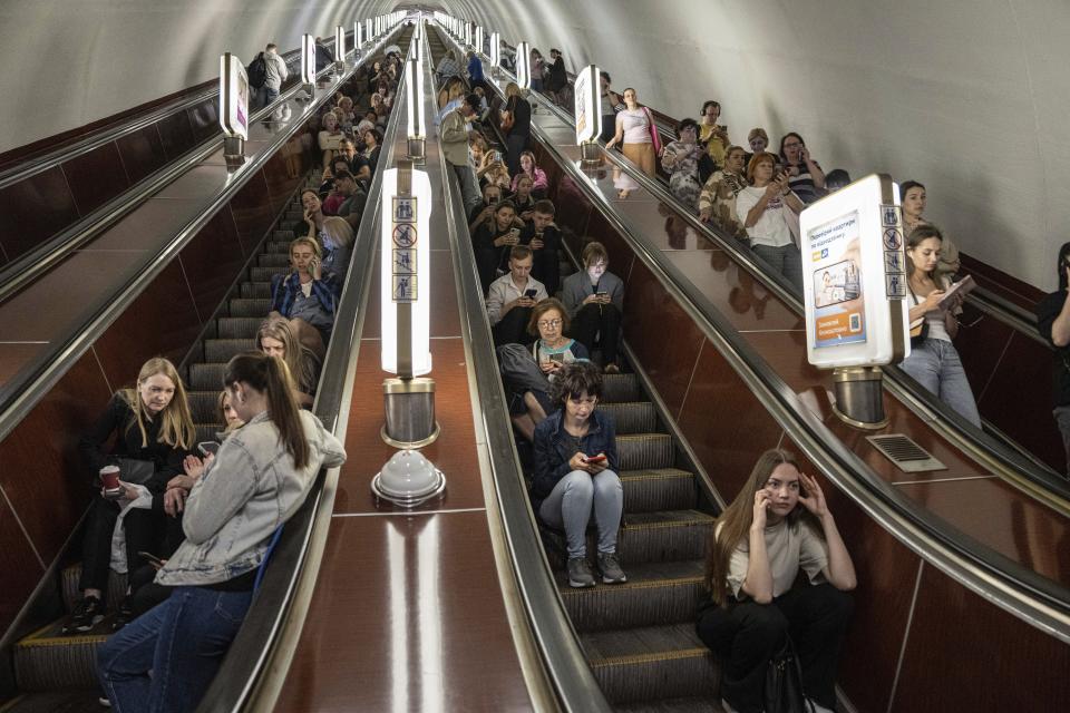 People take cover at metro station during a Russian rocket attack in Kyiv, Ukraine, Monday, May 29, 2023. Explosions have rattled Kyiv during daylight as Russian ballistic missiles fell on the Ukrainian capital. The barrage came hours after a more common nighttime attack of the city by drones and cruise missiles. (AP Photo/Evgeniy Maloletka)