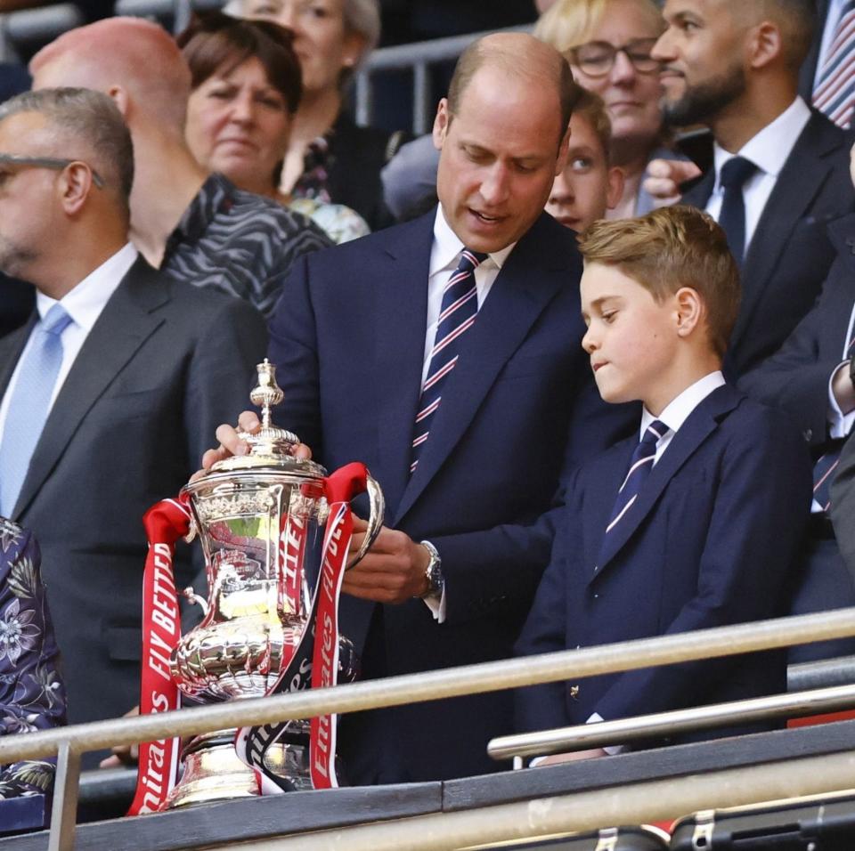 Prince William and Prince George look at the trophy at the English FA Cup final match