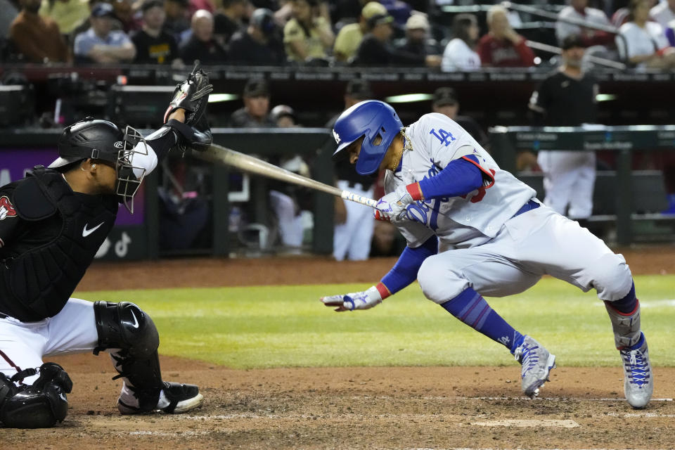 Los Angeles Dodgers' Mookie Betts, right, gets hit with a pitch as Arizona Diamondbacks catcher Gabriel Moreno, left, reaches for the ball during the ninth inning of a baseball game Thursday, April 6, 2023, in Phoenix. The Dodgers won 5-2. (AP Photo/Ross D. Franklin)