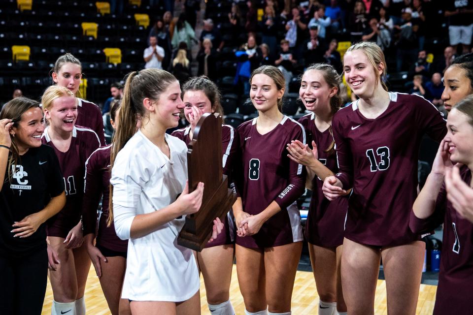 Dowling Catholic players stand with their trophy after a Class 5A state volleyball quarterfinal match against Ankeny Centennial on Oct. 31, 2022.