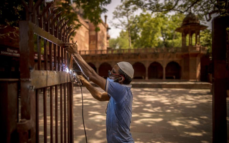 A worker welds a gate near the ticket booking counter at the Taj Mahal -  Anindito Mukherjee / Bloomberg