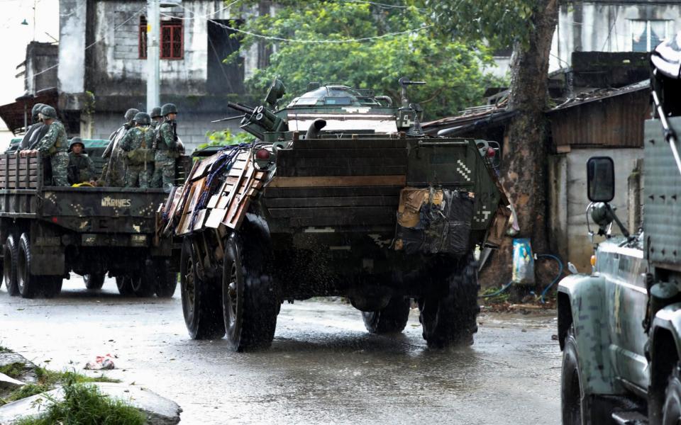 Military vehicles drive along a street while government forces continue their assault on insurgents from the Maute group, in Marawi - Credit: Jorge Silva/REUTERS