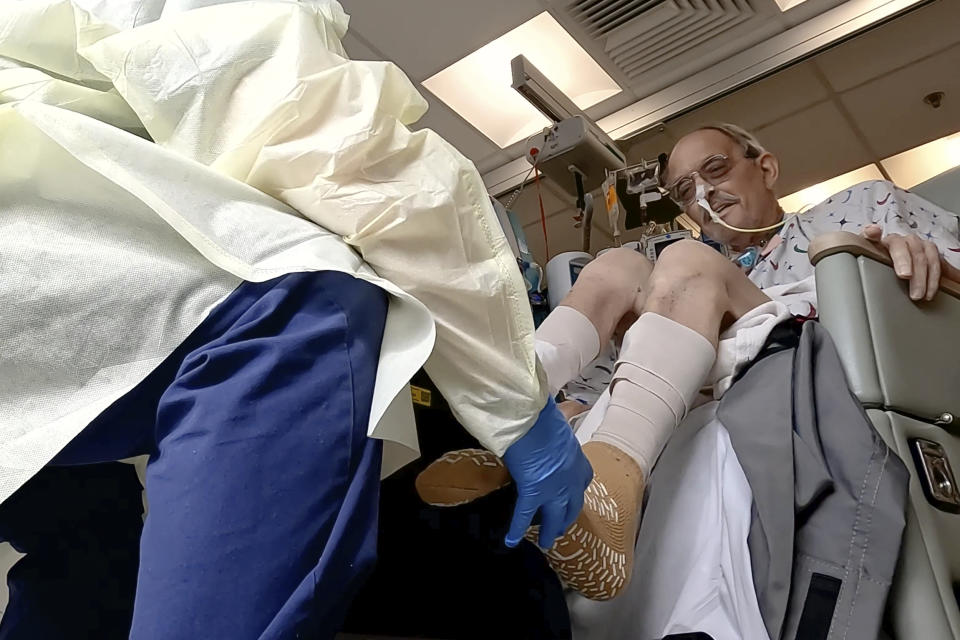 In this image from video provided by the University of Maryland School of Medicine, Lawrence Faucette, a pig heart transplant patient, works with a physical therapist at the school's hospital in Baltimore, Md., on Wednesday, Oct. 18, 2023. (Tom Jemski/University of Maryland School of Medicine via AP)