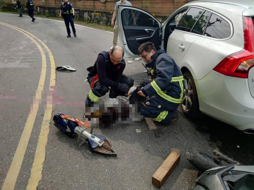 機車、汽車發生事故，後座女乘客受困車底，警消到場搶救。民眾提供