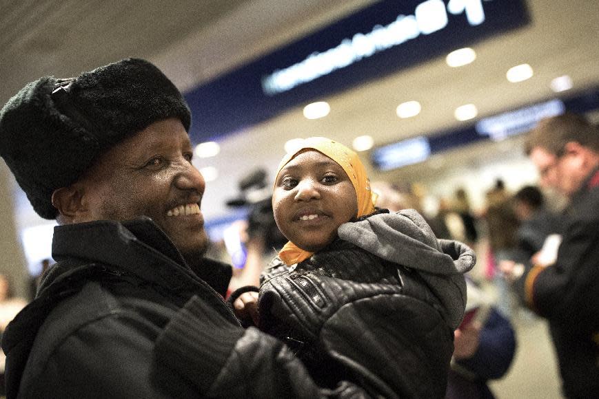 Mohamed lye holds his 4-year-old daughter Nimo as he was reunited with his wife Saido Ahmed Abdille and their other daughter Nafiso, 2, at Minneapolis–Saint Paul International Airport near Bloomington, Minn., after arriving from Amsterdam on Sunday, Feb. 5, 2017. (Jerry Holt/Star Tribune via AP)