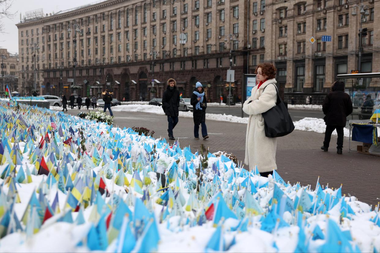 A woman looks at flags bearing symbols and colours of Ukraine that commemorate fallen Ukrainian soldiers at Independence Square (AFP via Getty Images)