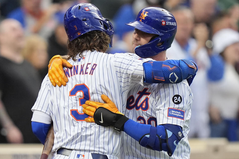 New York Mets' Pete Alonso (20) hugs Jesse Winker (3) after hitting a solo home run against the Philadelphia Phillies during the second inning of Game 3 of the National League baseball playoff series, Tuesday, Oct. 8, 2024, in New York. (AP Photo/Frank Franklin II)