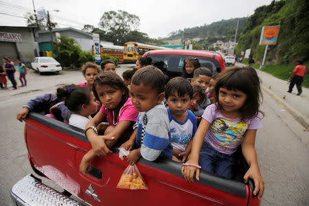 Honduran children fleeing poverty and violence hitchhike as they move in a caravan toward the United States, in Santa Rosa de Copan, Honduras October 14, 2018. REUTERS/ Jorge Cabrera