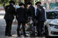 A group of boys look at a makeshift memorial for recently passed Associate Justice of the Supreme Court of the United States Ruth Bader Ginsburg outside her childhood home in Brooklyn, New York