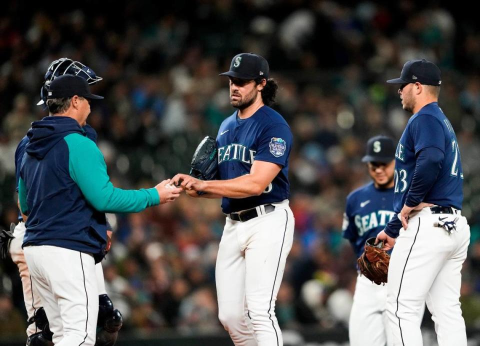 Seattle Mariners starting pitcher Robbie Ray (38) gives the ball to manager Scott Servais as he is taken out of the baseball game against the Cleveland Guardians during the fourth inning Friday, March 31, 2023, in Seattle. (AP Photo/Lindsey Wasson)