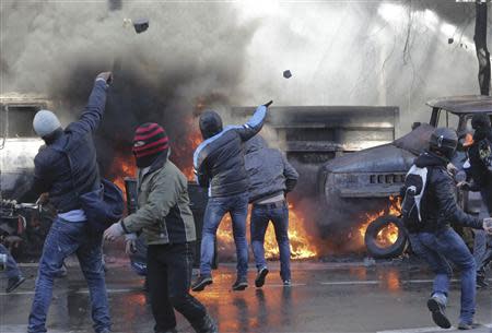 Protesters throw stones during clashes with police in Kiev February 18, 2014. REUTERS/Konstantin Chernichkin